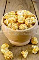 Popcorn caramel in wooden bowl on board