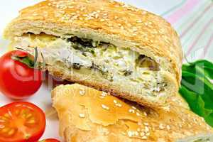 Roll filled with spinach and cheese on linen tablecloth