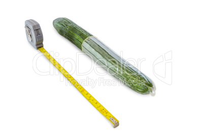 cucumber with condom and measuring tape on white