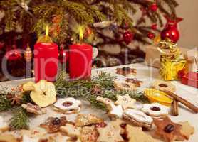 many colorful biscuits and candles in front of christmas tree