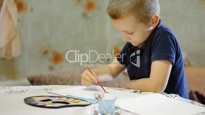 little beautiful boy draws in the room