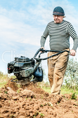 Farmer plowing the field. Cultivating tractor in the field