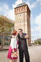 Bride and groom makes selfie before monument