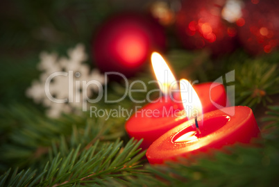 Macro of two Burning Candles with Christmas Background