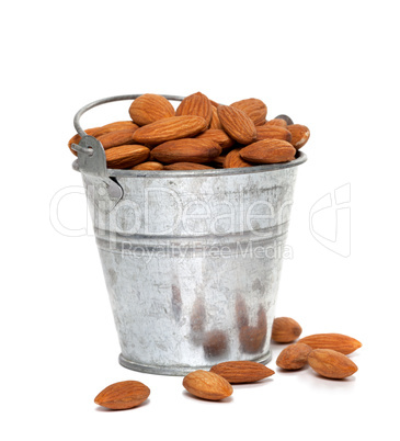 Tin bucket full of almonds on white background