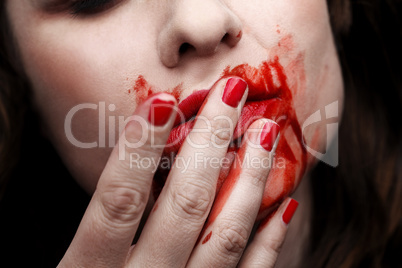 Female vampire licking blood off
