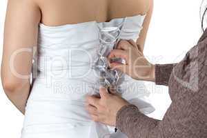Photo of bride's back and bridesmade's hands
