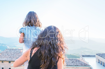 Mother and daughter looking at city panorama