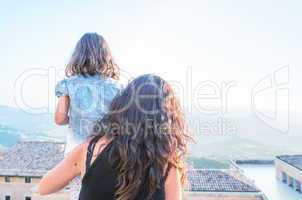 Mother and daughter looking at city panorama