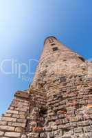 Ancient medieval brick tower against a blue sky