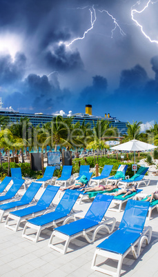 Storm approaching a beautiful tropical beach with deckchairs on