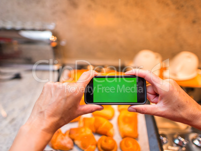 Photographing freshly cooked croissants with mobile phone and gr