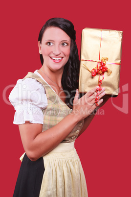 Junge Frau mit Dirndl und grossem Geschenk in der Hand