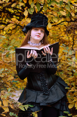 Cosplayer with a book in the autumn park
