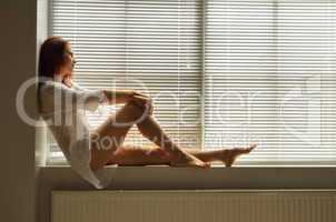 A woman on the windowsill at home