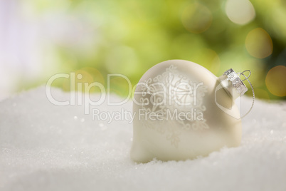 White Christmas Ornament on Snow Over an Abstract Background