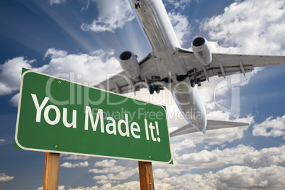 You Made It Green Road Sign and Airplane Above