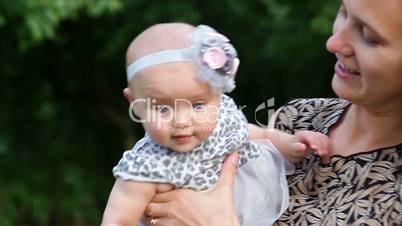 Young mother with child outside on a summer day