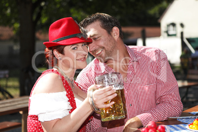 Couple in traditional costumes in a Bavarian beer garden