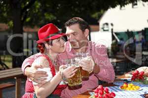 Couple in traditional costumes in a Bavarian beer garden
