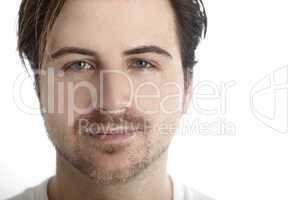 Attractive man in front of a white background looks straight int
