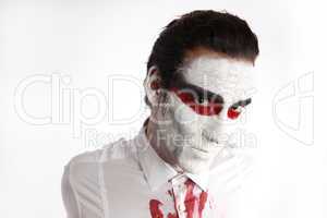 Man with white mascara and bloody shirt