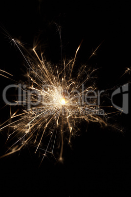 Burning sparkler on black background