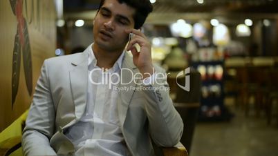 Businessman sitting in a café and talking on mobile phone
