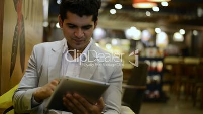 Businessman sitting in a café and using a digital tablet
