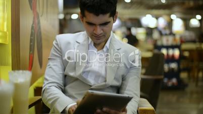 Businessman sitting in a café and using a digital tablet