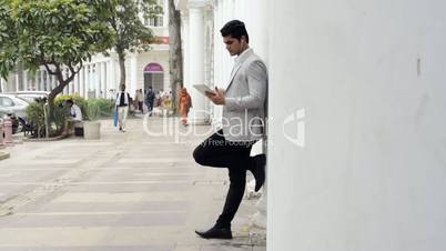 Businessman listening to music on a digital tablet
