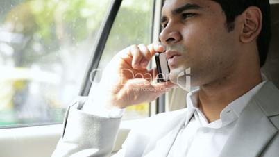 a man sitting in a car and talking on a mobile phone