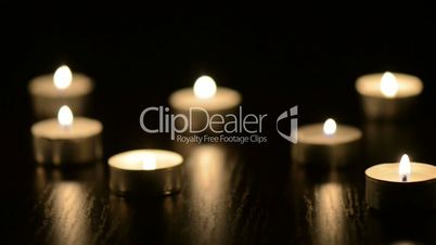 Many small flaming candles on black table