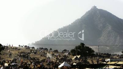 Locked-on shot of tent at Pushkar Fair with mountain in the background