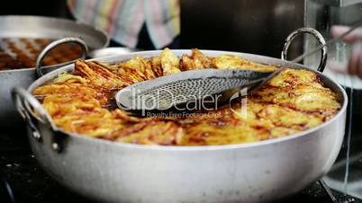 Locked-on shot of Indian sweet food Mal Puda being prepared in a wok at Pushkar Fair