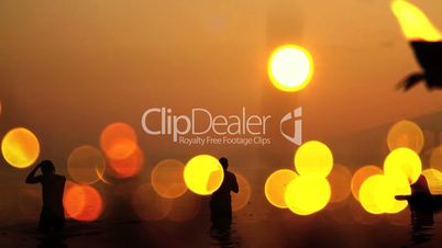 Pan shot of Hindu pilgrims bathing in the river during Kumbh Mela