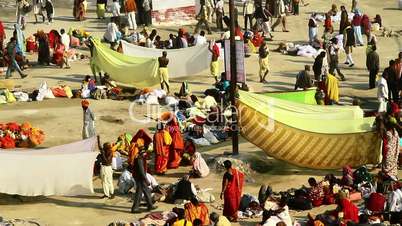 Locked-on shot of Hindu pilgrims at riverbank during Kumbh mela