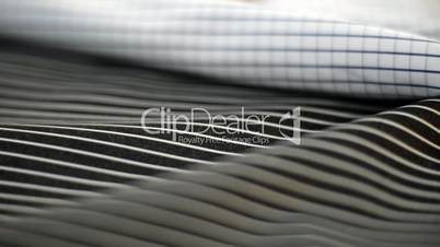 Pan shot of fabrics with measuring instrument in textile factory