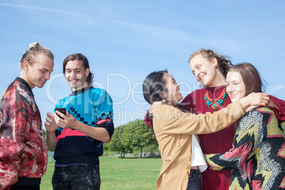 Men stand next group of women hugging each other