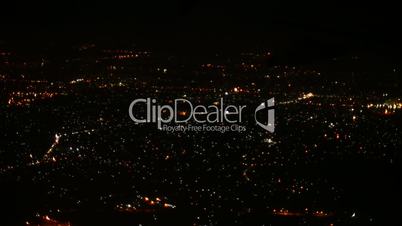 Tracking shot of the city lit up at night from aerial