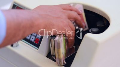 Locked-on shot of Indian currency notes being counted in a machine