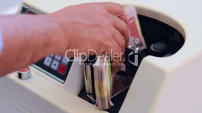 Locked-on shot of Indian currency notes being counted in a machine