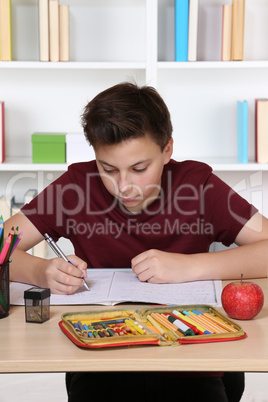 Schüler beim Schreiben in sein Heft in der Schule