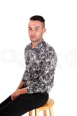 Young man sitting on chair.