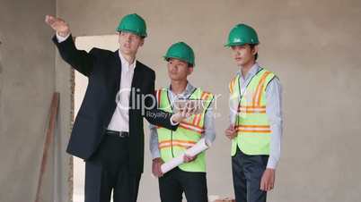 3of23 Manual worker, engineer and architect with blueprint in construction site