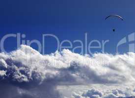 Silhouette of paraglider and blue sunny sky