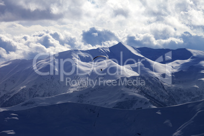 Skydiver at evening cloudy mountains