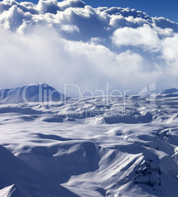 Snowy sunlight plateau and sky with clouds