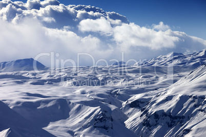 Snowy sunlight plateau and blue sky with clouds