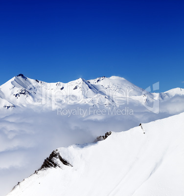 Mountains in clouds at nice day. View from ski slope.